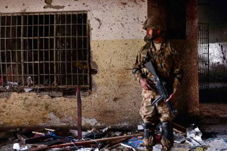 Soldado paquistanês faz guarda em frente à escola que sofreu ataques terroristas no em Peshawar (A Majeed/AFP)