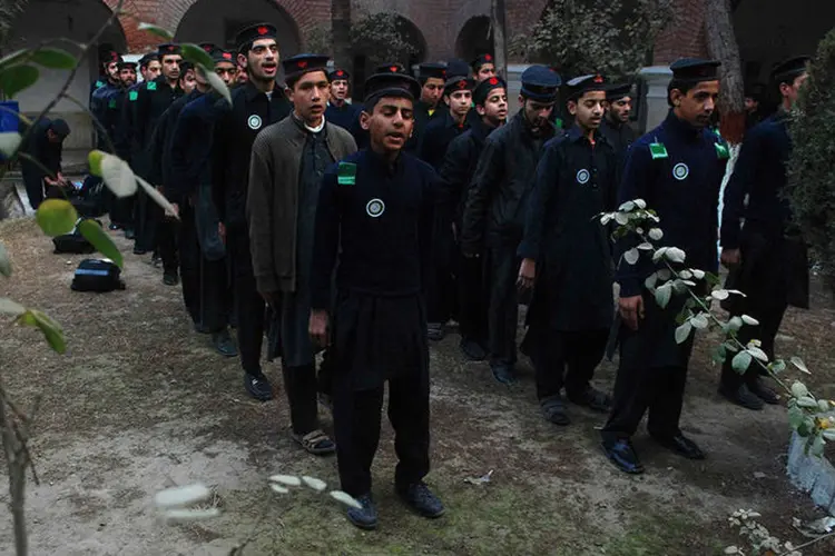 Estudantes rezam durante assembleia escolar após reabertura em Peshawar, no Paquistão  (REUTERS/Khuram Parvez)