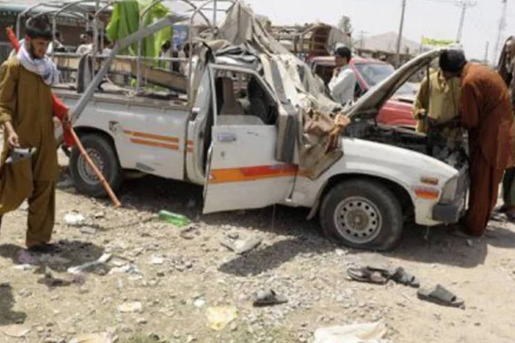 Paquistaneses caminham ao lado de local de explosão em Quetta: outras pessoas ficaram feridas (Banaras Khan/AFP)