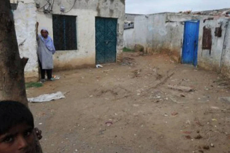 
	Mulher crist&atilde; e menino ao lado da casa de Rimsha, em Islamabad: segundo documento da defesa, a menina &quot;parece analfabeta e sua idade mental parece inferior a sua idade f&iacute;sica&quot;
 (Aamir Qureshi/AFP)