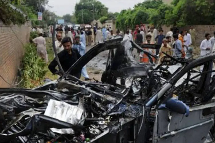 
	Pessoas se re&uacute;nem em torno do local onde um carro-bomba explodiu em Peshawar: esse &eacute; o pior atentado contra americanos ocorrido no pa&iacute;s
 (A. Majeed/AFP)