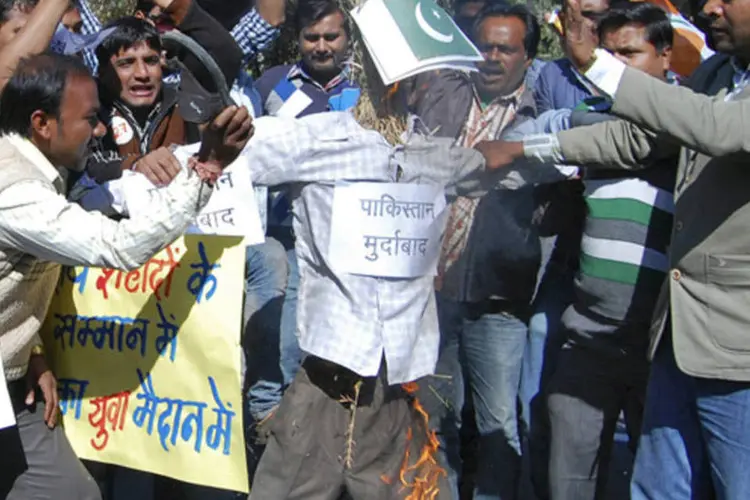 Ativistas gritam palavras de ordem enquanto batem em efígie que representa o Paquistão, durante um protesto na Índia (Raj Patidar/Reuters)