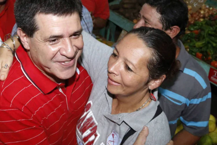 Candidato do partido Colorado para a presidência do Paraguai abraça eleitora em um mercado durante uma visita a cidade de Luque (Reuters)