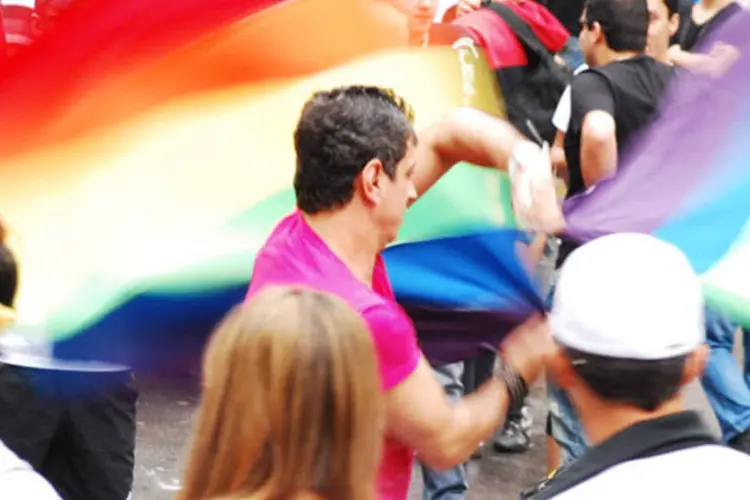 Homem agita bandeiras do orgulho gay durante o evento (Beraldo Leal/flickr)