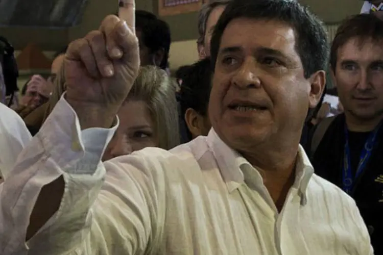 
	Horacio Cartes exibe o dedo sujo de tinta ap&oacute;s votar: a realiza&ccedil;&atilde;o de elei&ccedil;&otilde;es pac&iacute;ficas e democr&aacute;ticas foi a condi&ccedil;&atilde;o imposta pelo membros do Mercosul para retirar a suspens&atilde;o do Paraguai
 (AFP / Pablo Porciuncula)