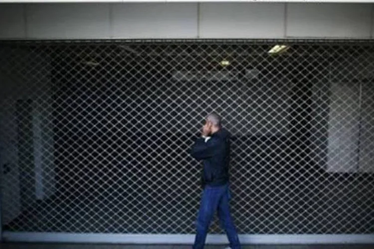 Um homem observa uma estação de metrô fechada durante paralisação (Angelos Tzortzinis/AFP)