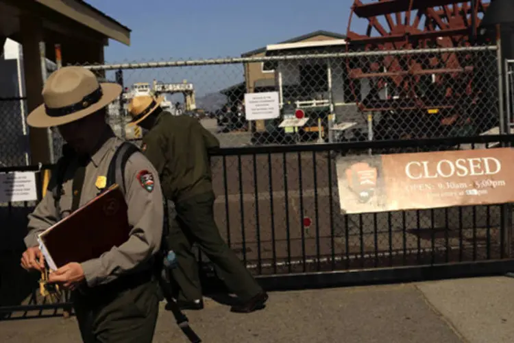 Guarda florestal fecha o portão para o Parque Nacional San Francisco Maritime, na Califórnia, durante a paralisação do governo americano (Robert Galbraith/Reuters)