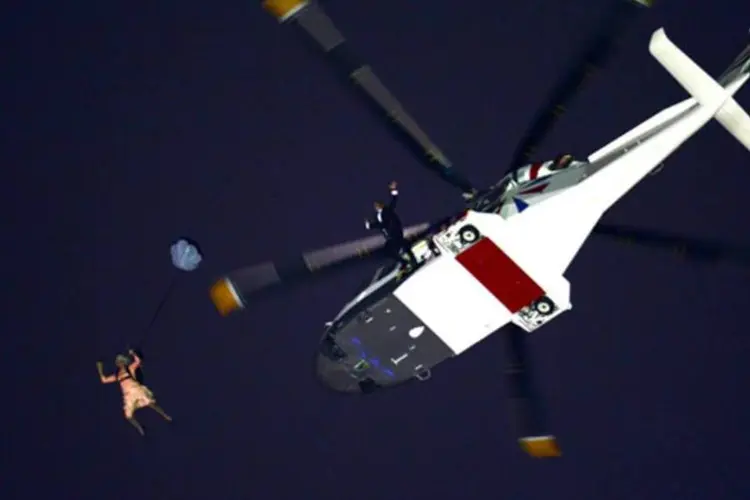 Helicóptero real apareceu sobre o estádio e, em meio ao clamor do público, James Bond abriu a porta da aeronave e saltou de paraquedas, junto com a suposta rainha. (Getty Images)