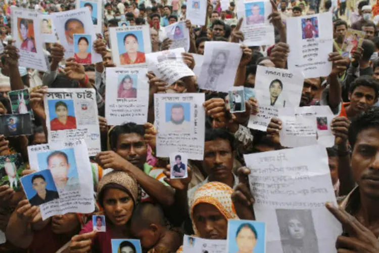 
	Parentes mostram fotos de v&iacute;timas de desabamento de pr&eacute;dio em Bangladesh em protesto contra as condi&ccedil;&otilde;es de seguran&ccedil;a do local:&nbsp;o desabamento do edif&iacute;cio, constru&iacute;do sem autoriza&ccedil;&atilde;o legal, causou a morte de 387 pessoas.
 (REUTERS/Andrew Biraj)