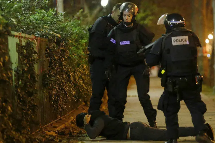 
	Homem no ch&atilde;o &eacute; abordado por policiais em Paris, ap&oacute;s ataques
 (Christian Hartmann/Reuters)