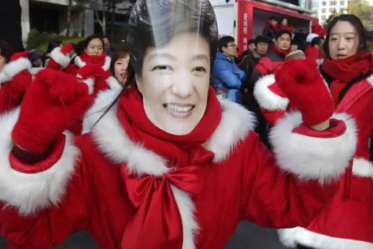 
	Pessoa com m&aacute;scara de Park Geun-Hye, que deve se tornar a primeira mulher presidente da Coreia do Sul
 (Getty Images)