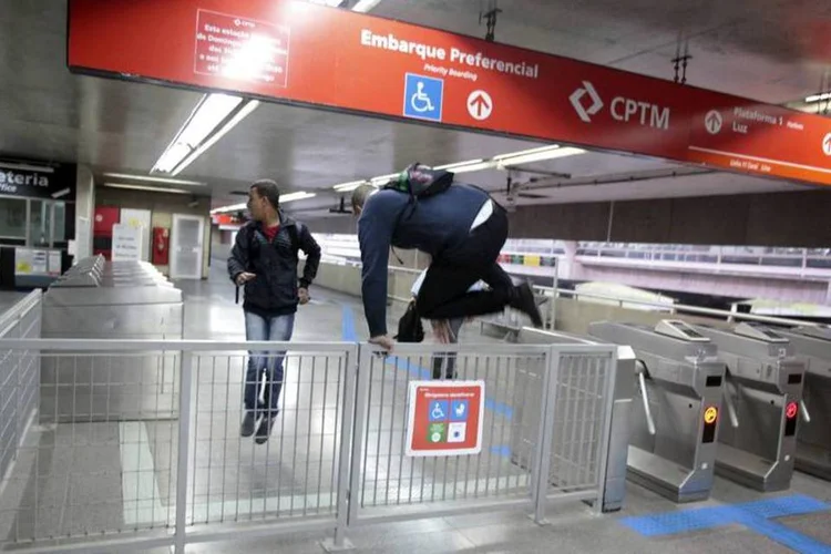 
	Passageiros pulam a grade de entrada da esta&ccedil;&atilde;o Itaquera
 (Chico Ferreira/Reuters)