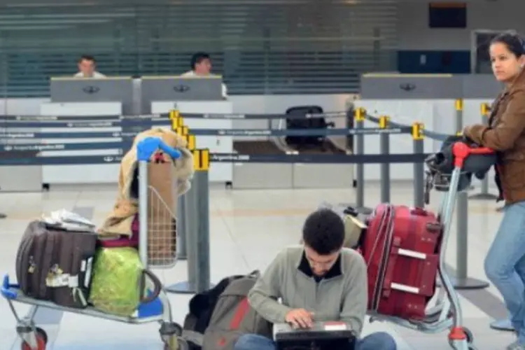 Os passageiros que utilizam o Aerporto Internacional de Ezeiza, o maior da Argentina, são informados sobre a possibilidade de normalização plena apenas para o dia 20 (AFP / Daniel Garcia)