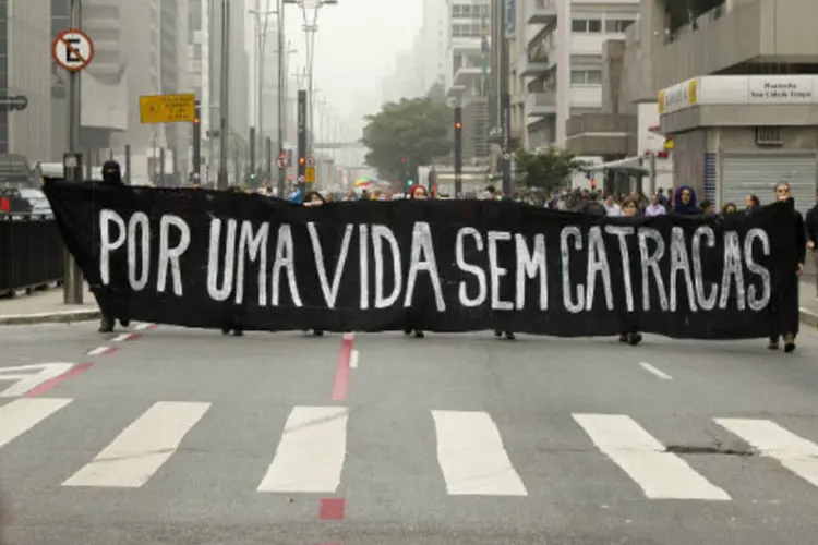 
	Integrantes do Movimento Passe Livre carregam bandeira contra catracas
 (Marcos Santos/USP Imagens)