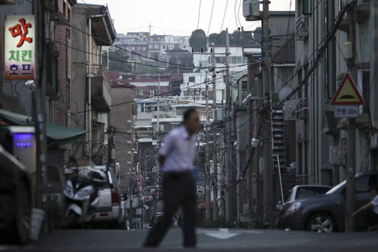 Pedestre em rua de Seul, na Coreia do Sul: exportações do país são um bom barômetro da demanda global (Woohae Cho/Bloomberg)