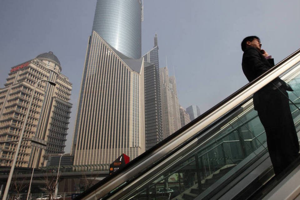 
	Pedestre em escada rolante em Xangai
 (Tomohiro Ohsumi/Bloomberg)