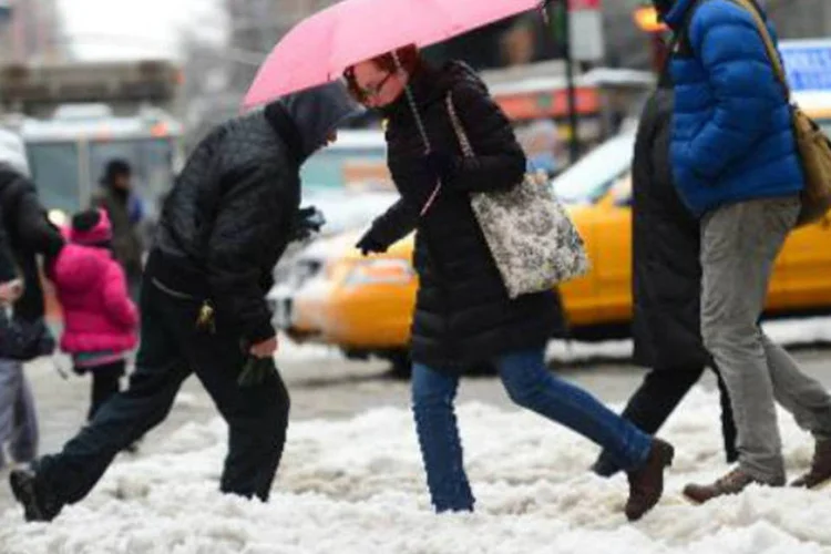 Pedestres driblam a neve em Nova York: Nova York e Nova Jersey enfrentam uma nova tempestade desde o início desta quarta (Emmanuel Dunand/AFP)