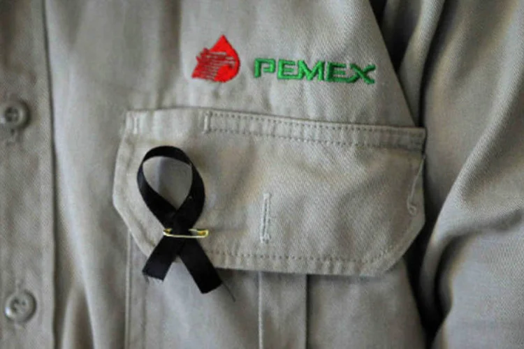 
	Funcion&aacute;rio da Pemex usa fita preta em sinal de luto &agrave;s v&iacute;timas da explos&atilde;o na sede da estatal
 (REUTERS/Edgard Garrido)