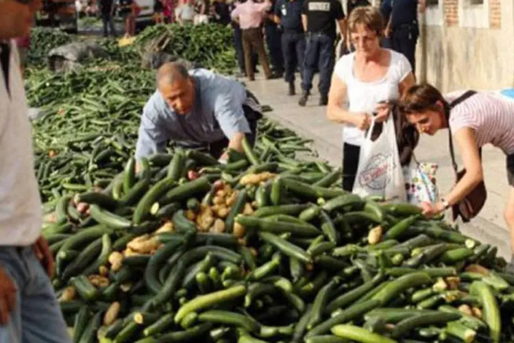 Consumidores escolhem pepinos doados por agricultores, em protesto pela acusação  (Raymond Roig/AFP)