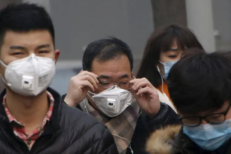 Pessoas se protegem contra poluição em Pequim (Kim Kyung-Hoon/REUTERS)