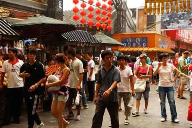 
	Pessoas andam Wangfujing, regi&atilde;o de compras em Pequim: o n&uacute;mero anual de turistas que visita Pequim &eacute; cerca de 5 milh&otilde;es, segundo as autoridades
 (Cameron Spencer/Getty Images/Getty Images)