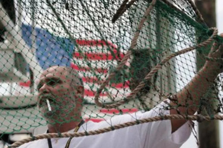 Pescador mexe em rede de pesca em Greens Ditch, Louisiana ( Joe Raedle/AFP)