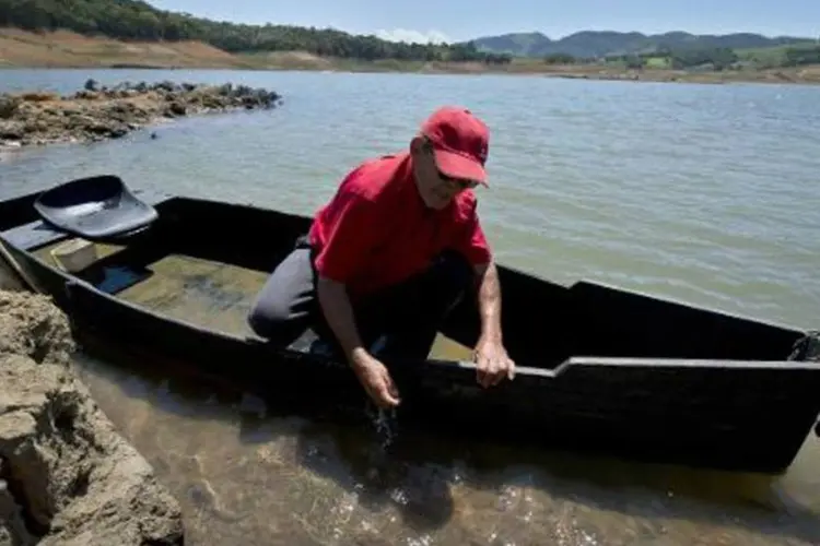 Ernane da Silva em seu pequeno barco no rio Piracaia, São Paulo: estado sofre com a pior seca em 80 anos (Nelson Almeida/AFP)