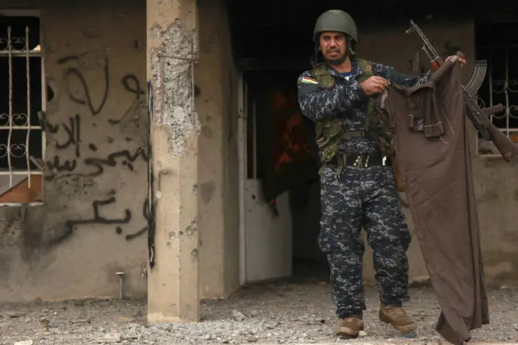 Peshmerga segura roupa de militante do EI: grupo perdeu controle de várias regiões do Iraque (Ari Jalal/Reuters)
