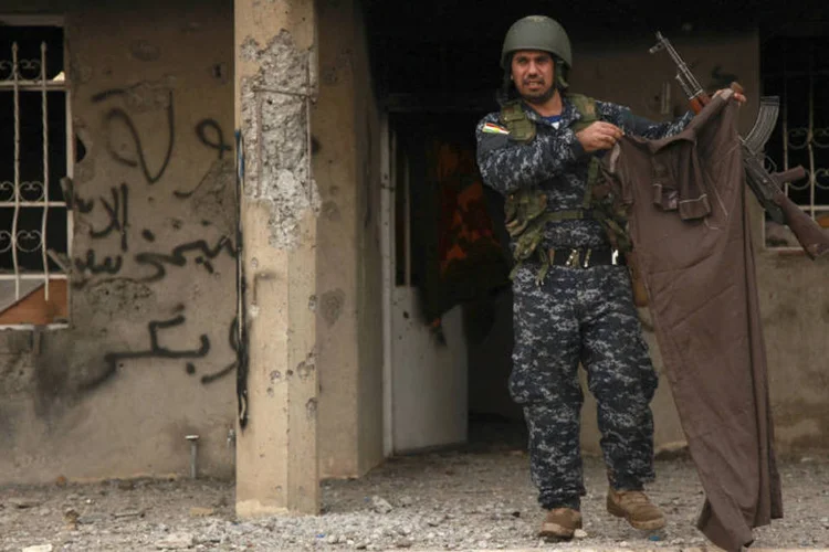 Peshmerga segura roupa de militante do EI: grupo perdeu controle de várias regiões do Iraque (Ari Jalal/Reuters)