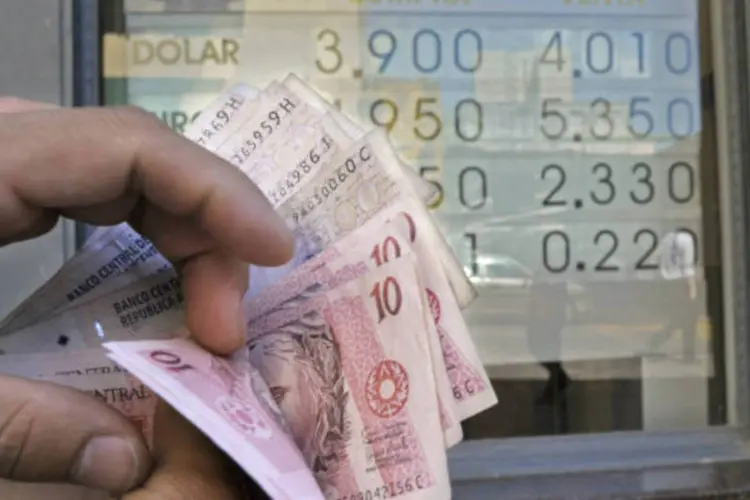 
	Pessoa segura notas de real e peso argentino: vendedores ilegais da moeda, conhecidos como&nbsp;&quot;arbolitos&quot;, oferecem mesma taxa de&nbsp;c&acirc;mbio&nbsp;que a da sexta passada
 (Diego Giudice/Bloomberg)