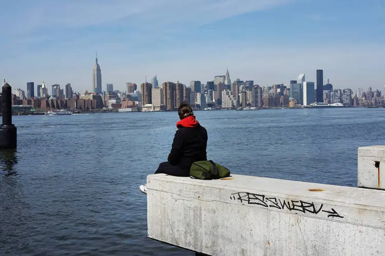 
	Pessoa observa Manhattan na beira do rio no lado do Brooklyn, que se desenvolve rapidamente
 (Spencer Platt/Getty Images)