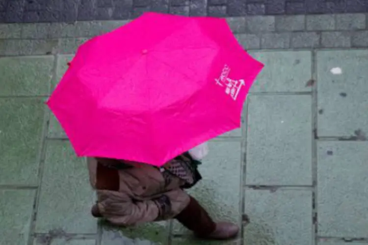 
	Pessoa segura guarda-chuva: segundo dados da Sabesp, faltam apenas 5,7 mm para que o acumulado de chuvas em abril no sistema ultrapasse a m&eacute;dia hist&oacute;rica para o m&ecirc;s, 89,3mm
 (AFP)