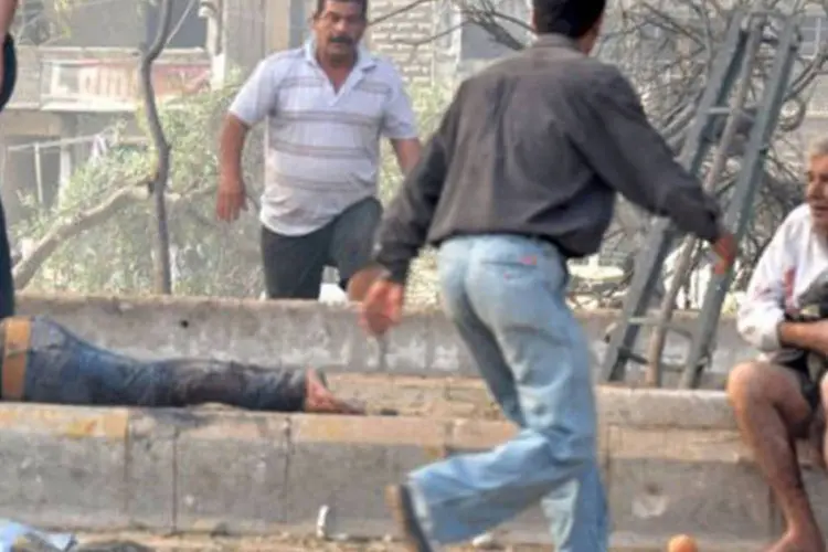 Pessoas atordoadas em meio a corpos vagam pelo local do atentado em Damasco (©AFP / Ho)