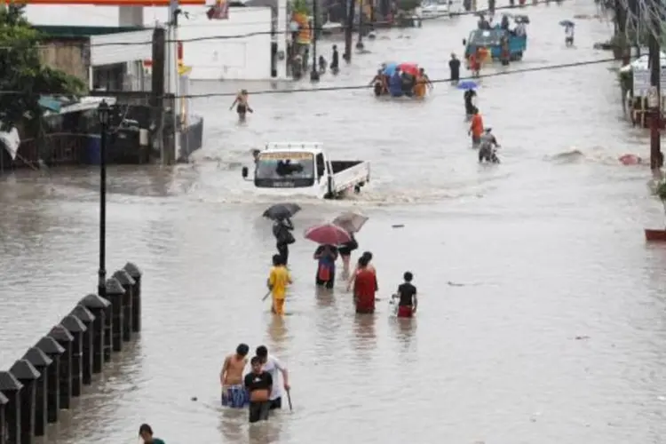 Pessoas tentam evacuar diante das enchentes em Manila, nas Filipinas (Erik De Castro/Reuters)