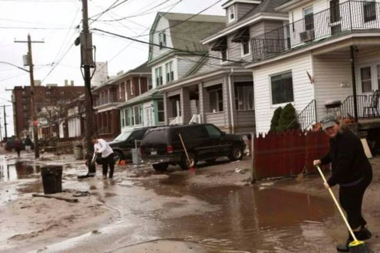 Cidadãos limpam ruas no bairro do Queens, que foram danificadas e inundadas pela passagem da tempestade Sandy (Gil Cohen Magen/Reuters)