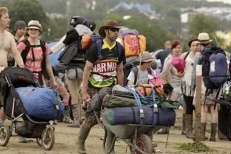 Pessoas deixam o festival de Glastonbury, na fazenda Worthy, em Somerset. A lama ficará como recordação tão forte quanto a música (Cathal McNaughton/Reuters)