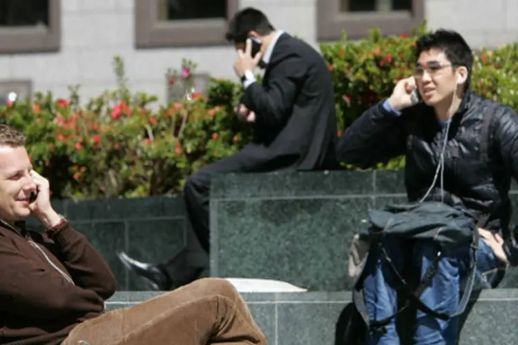 Pessoas falando no celular: representantes das empresas de telefonia móvel que operam na América Latina concordaram em trocar informações por meio da base de dados de IMEI (Getty Images)