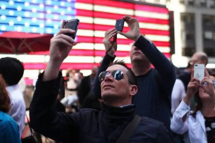 Pessoas na Time Square em NY tiram fotos dos telões no dia do IPO do Facebook (Spencer Platt/Getty Images)
