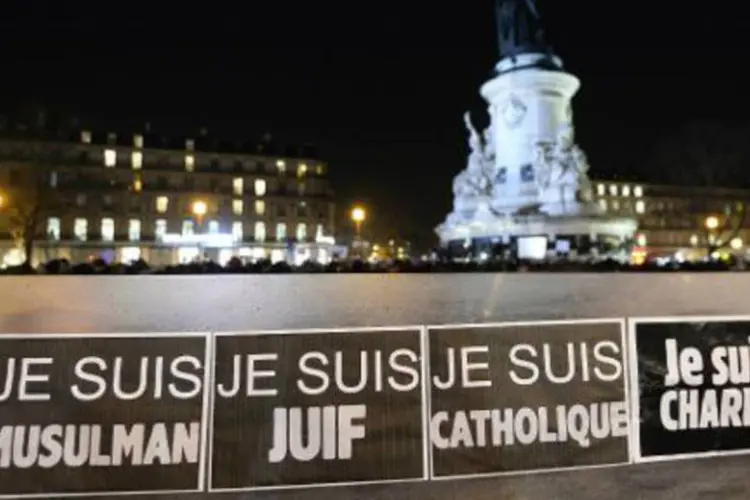 Pessoas seguram cartazes durante ato na Praça da República, em Paris (Bertrand Guay/AFP)