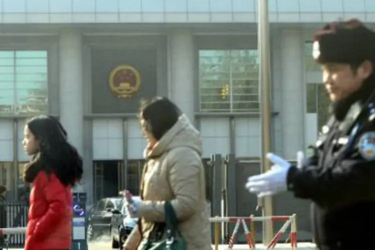 Pessoas passam em frente a um tribunal em Pequim: um dos ativistas foi condenado a uma pena de 18 meses de prisão (Goh Chai Hin/AFP)