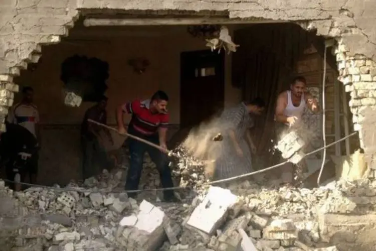 Homens removem destroços após ataques a bomba em Bagdá, capital do Iraque (Saad Shalash/Reuters)