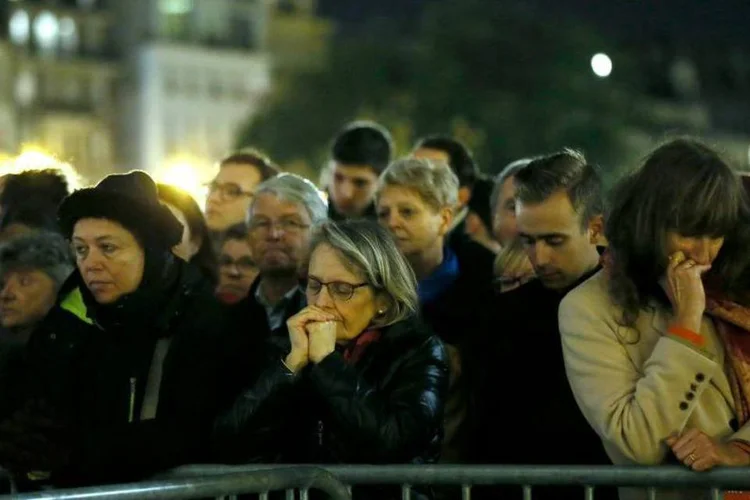 
	Pessoas rezam em Paris ap&oacute;s atentado: tr&ecirc;s feridos que estavam em estado grave faleceram
 (REUTERS/Gonzalo Fuentes)