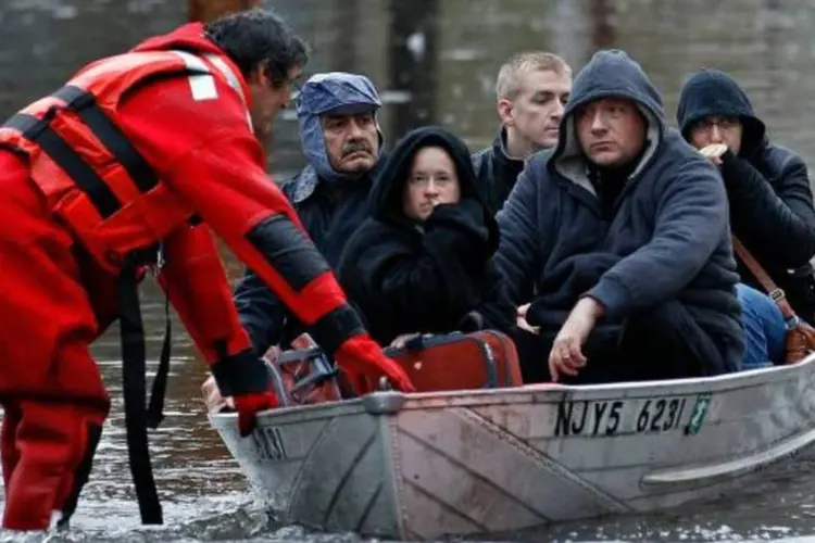 Pessoas são transportadas de bote em Little Ferry, Nova Jersey (Adam Hunger/Reuters)