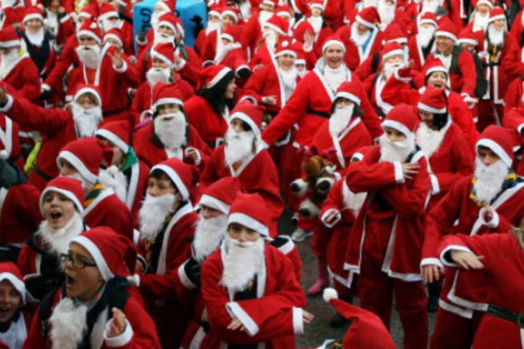
	Pessoas fantasiadas de Papai Noel: trabalhar no Natal rende pagamento em dobro ou folga compensat&oacute;ria
 (Jeff J Mitchell/Getty Images)