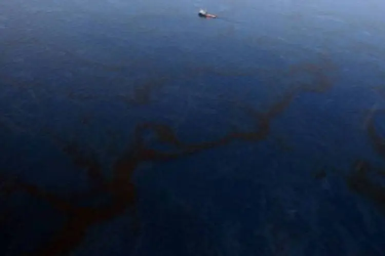 Barco trabalha na limpeza enquanto o petróleo espalha nas águas do Golfo do México (.)