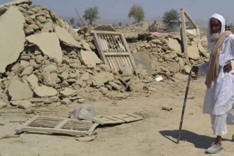 Homem caminha e área destruída por terremoto no Paquistão: "há áreas em que não há ninguém fornecendo ajuda", disse prefeito de região atingida (Naseer Ahmed/Reuters)