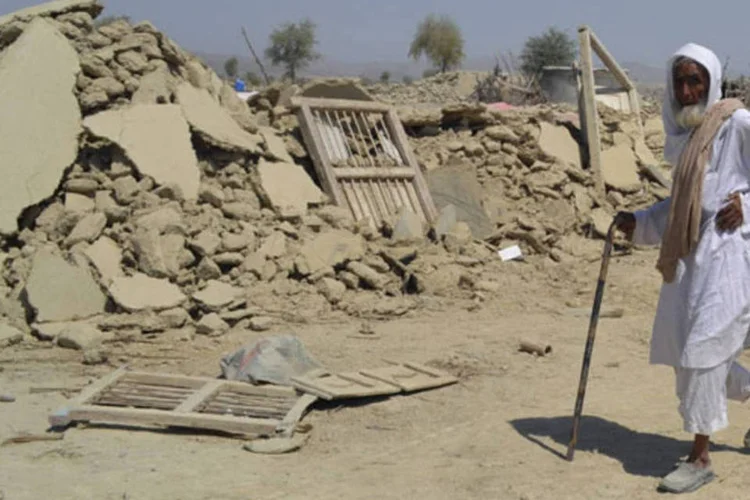 
	Homem caminha e &aacute;rea destru&iacute;da por terremoto no Paquist&atilde;o: o capit&atilde;o Usman Lahore disse que as v&iacute;timas, incluindo uma mulher e uma crian&ccedil;a, morreram de queimaduras e asfixia
 (Naseer Ahmed/Reuters)