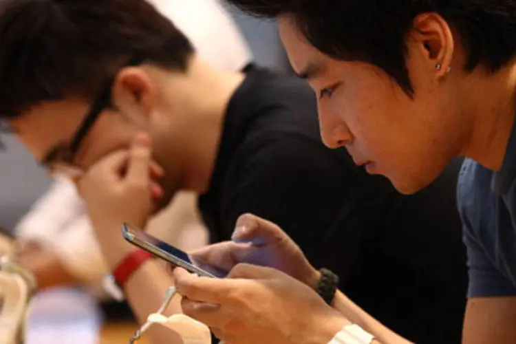 
	Pessoas usam smartphones: jovens mant&eacute;m o h&aacute;bito de passar cinco horas por dia conectado &agrave; rede
 (Getty Images)