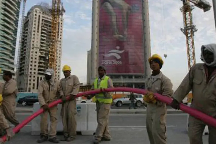 Trabalhadores em Doha, no Catar: se o ritmo atual for mantido, ao menos 4.000 operários imigrantes poderão morrer antes da realização do torneio, diz organização (Goh Chai Hin/AFP)