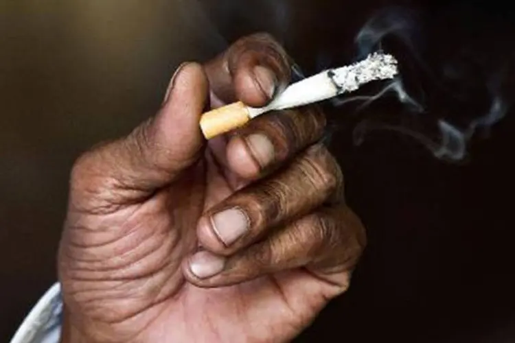 
	Homem fuma um cigarro: o aumento foi liderado pelo fumo (3,63%)
 (Prakash Singh/AFP)